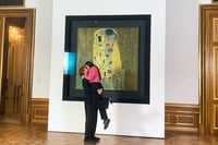 Se besan frente a obra de Klimt