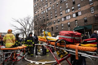 Firefighters work outside an apartment building after a fire in the Bronx, Sunday, Jan. 9, 2022, in New York. (AP Photo/Yuki Iwamura)
