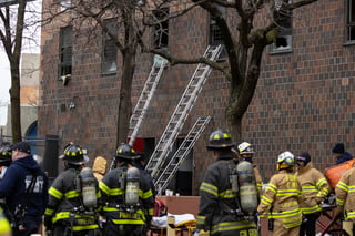 Ladders are seen erected beside the apartment building where a fire occurred in the Bronx on Sunday, Jan. 9, 2022, in New York. (AP Photo/Yuki Iwamura)