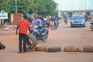 Ougadougou (Burkina Faso), 30/09/2022.- A man places tyres across a road in Ouagadougou, Burkina Faso, 30 September 2022. Gunshots have been heard near the presidential palace in Ouagadougou with what some residents claim to be an alleged coup attempt. Access has been blocked by the military to some government buildings including the national assembly and the national broadcaster. In January 2022 the current head of state, Lt-Col Paul-Henri Damiba, ousted President Roch Kabore through a coup. Lieutenant Colonel Paul-Henri Damiba has called for calm. (Golpe de Estado) EFE/EPA/ASSANE OUEDRAOGO
