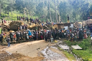 In this image supplied by the International Organization for Migration, villagers react after a body was discovered amongst the debris form a landslide in the village of Yambali in the Highlands of Papua New Guinea, Monday, May 27, 2024. (Mohamud Omer/International Organization for Migration via AP)