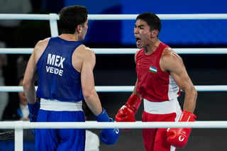 Uzbekistan's Asadkhuja Muydinkhujaev, right, celebrates after defeating Mexico's Marco Verde in their men's 71 kg final boxing match at the 2024 Summer Olympics, Friday, Aug. 9, 2024, in Paris, France. (AP Photo/John Locher)