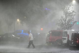 Max Watts, oriundo de Buford, Georgia, camina por un estacionamiento para revisar un tráiler estacionado fuera del hotel en el que espera el paso del huracán Milton, el miércoles 9 de octubre de 2024, en Tampa, Florida. (AP Foto/Julio Cortez)