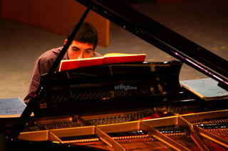 El joven músico lagunero Sergio Vargas Escoruela se mantiene frente al piano Yamaha del Teatro Isauro Martínez (TIM) en el mediodía de este martes. Está frente a estudiantes de distintas instituciones educativas de la ciudad, en uno de sus conciertos didácticos, donde se preocupa por compartir sus conocimientos musicales.