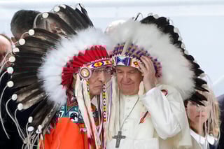 ARCHIVO - El papa Francisco se pone un tocado indígena durante una reunión con las comunidades indígenas en la iglesia católica de Nuestra Señora de los Siete Dolores en Maskwacis, cerca de Edmonton, Canadá, el lunes 25 de julio de 2022. (AP Foto/Gregorio Borgia, Archivo)
