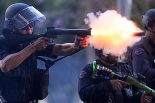 A police officer fires a soft round near the metropolitan detention center of downtown Los Angeles, Sunday, June 8, 2025, following last night's immigration raid protest. (AP Photo/Eric Thayer)