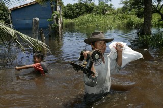 Un hombre y un niño rescatan sus pertenencias en una población cercana a la Trinidad, luego de ser afectados por las inundaciones que azotan la amazonía boliviana. (EFE) 
