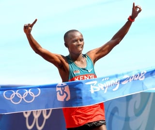 El atleta keniano Samuel Kamau Wansiru celebra su nuevo récord olímpico en el maratón masculino durante la final de esta modalidad disputada en el Estadio Nacional de Pekín. (EFE)