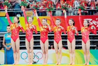 Las gimnastas Fei Cheng, Yilin Yang, Li Shanshan, He Kexin, Jiang Yuyuan y Linlin Deng posan en el podio con sus medallas de oro conseguidas en los Juegos Olímpicos de Beijing.