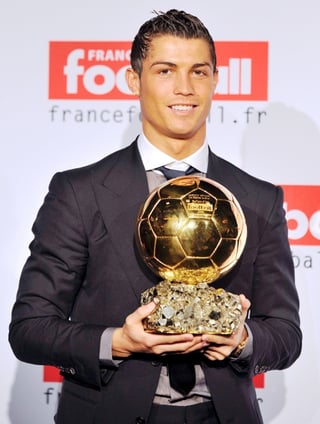 El delantero portugués del Manchester United, Cristiano Ronaldo, posa con el Balón de Oro, concedido al mejor jugador europeo del año, el el estudio de TF1 en Boulogne Billancourt, París, Francia, hoy domingo 7 de diciembre. (EFE)