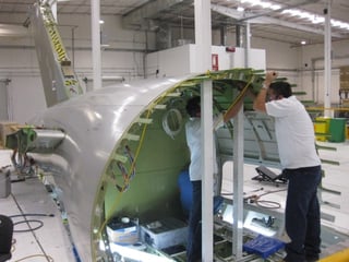 Técnicos de Bombardier en Querétaro trabajan sobre un fuselaje y arneses eléctricos del avión ejecutivo Global Express. Todos sus materiales como cables, tornillos, son comprados en México.