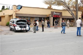 Ataque. Policías acordonan el área afuera del restaurante donde estaba Torres Charles. Una patrulla resultó baleada.