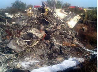 Escombro. Bomberos observan los restos de la aeronave que quedó destruida tras el incendio.