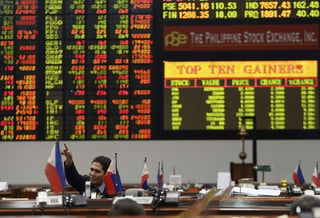 Mercados. Un agente de bolsa filipino gesticula mientras la pantalla electrónica muestra el valor que han alcanzado las acciones. (ARCHIVO)