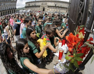 Homenaje. Peregrinos y turistas depositan flores, velas y notas en la fachada de catedral, símbolo de la ciudad, en espontáneo homenaje a los fallecidos en el accidente de tren en Santiago de Compostela. 