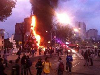 El árbol de navidad fue incendiado durante una manifestación por el alza al precio del Metro. (Tomada de Twitter)