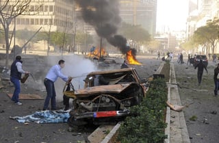 Ataque. Varios ciudadanos trabajan en la extinción de las llamas que le ha costado la vida al exministro Mohamed Chatah 