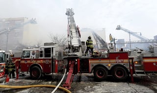 Derrumbe. Varios bomberos trabajan en la extinción de un incendio declarado en un edificio del barrio de Harlem, Nueva York.