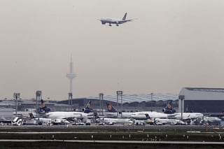 Flota. Un grupo de aviones permanecen estacionados mientras una aeronave abandona el aeropuerto.