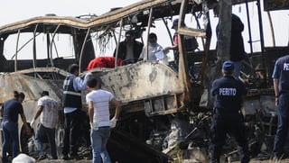 Accidente. Autoridades recuperan los restos de las víctimas en el autobús turístico.