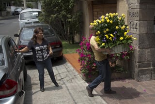 Un hombre se vio entrando con flores amarillas a la casa funeraria en donde arribaron los restos de García Márquez. (AP)