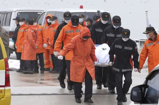 Cuerpos. Los equipos de rescate llevan el cuerpo de un pasajero a bordo El ferry Sewol que se hundió en el agua de la costa sur.