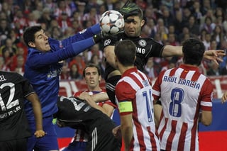 El portero belga del Atlético de Madrid Thibaut Courtois (2i) intenta atrapar el balón entre sus compañeros Gabi y Raúl García. 