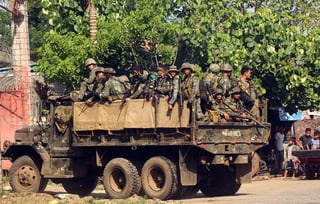 Enfrentamientos.  Marinos filipinos regresan a su campamento tras un despliegue en el pueblo de Patikol, en Jolo. (EFE)