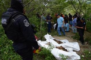 Fosas. Integrantes de la Policía Federal y militares apoyan a expertos forenses en la zona donde localizaron los cuerpos de las fosas.
