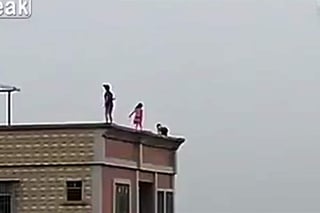 Los tres infantes toman por diversión arriesgar sus vidas en el filo de la azotea de un elevado edificio. (YouTube)