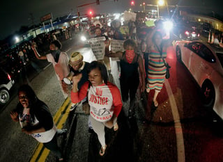 Enojo. Cientos de personas salen a las calles para protestar por la muerte de un joven de color en Missouri. 