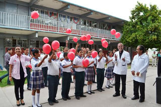 Prevención. Adolescentes lanzan  globos rojos, color del sida, para decirle 'adiós' a la ignorancia.