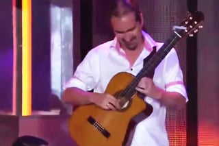El hombre finge tocar su guitarra acústica, pero el sonido de una eléctrica evidencia su playback. (YouTube)