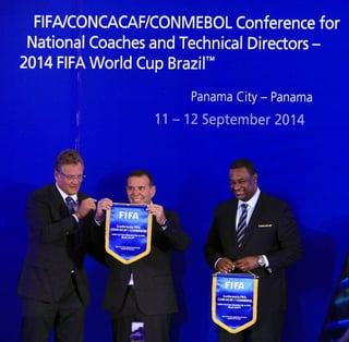 El secretario general de la FIFA, Jerome Valcke (i), le entrega un banderín al presidente de la Conmebol, Juan Ángel Napout (c).