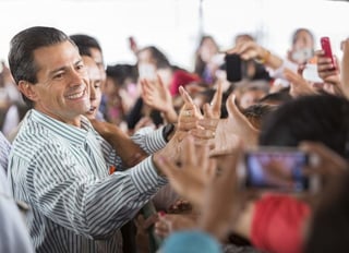 Baño de pueblo. El presidente Peña saluda feliz  a un grupo de mujeres que lo vitorearon.