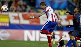 El delantero croata del Atlético de Madrid, Mario Mandzukic (i), cabecea para conseguir el tercer gol 'colchonero' ante Olympiacos. (Fotografías de EFE)