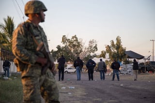 Muerte. Un soldado vigila la escena del enfrentamiento que dejó once personas muertas. (ARCHIVO)