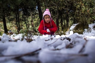 Afecta frío. Fotografía en donde se observa a una pequeña jugando con un poco de nieve. (INTERNET)