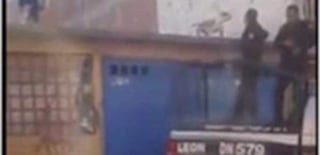 En la grabación compartida en Facebook, se ve a un hombre en el techo que amenaza con lanzar un objeto a los uniformados y a dos de ellos desenfundar sus armas. (YouTube)
