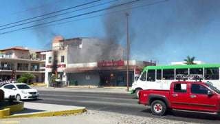Riesgos. Otro banco en Puerto Vallarta fue incendiado mientras circulan autos por la acera.
