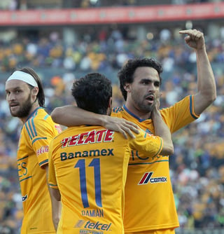 Enrique Esqueda celebrando junto a Damián Álvarez el primer gol que anotaron los Tigres a las Chivas ayer. (Notimex)