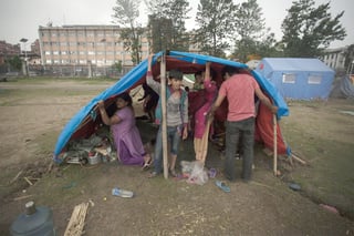 Penas. Sobrevivientes de los terremotos en Nepal se protegen del fuerte viento con una techumbre.