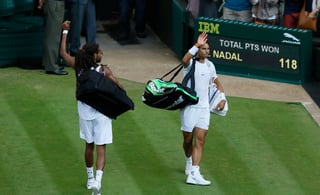 Dustin Brown abandona la cancha del torneo de Wimbledon con el brazo levantado; Nadal sólo dice adiós. (AP)