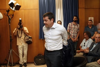 Alexis Tsipras. El primer ministro griego se quita el saco antes de iniciar la rueda de prensa. (EFE)
