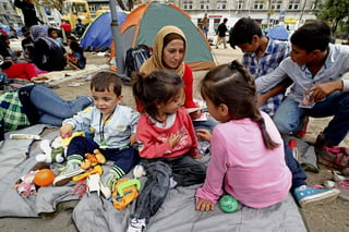 Migración. Una familia afgana descansa en una plaza pública de Belgrado, donde se les atendió.