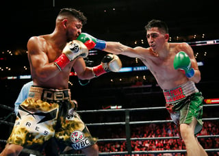 Leo Santa Cruz golpea en el rostro a Abner Mares durante la pelea celebrada ayer en el Staples Center. El 'Terremoto' es nuevo campeón pluma de la Asociación Mundial de Boxeo. (AP)