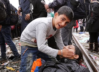 Migración. Un niño llora tratando de ayudar a su mamá que cayó desmayada en el trayecto.