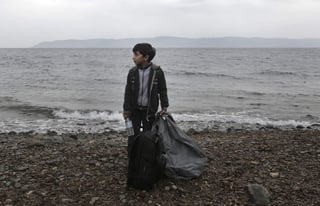 Travesía. Un niño sirio refugiado carga sus maletas tras cruzar el mar. 