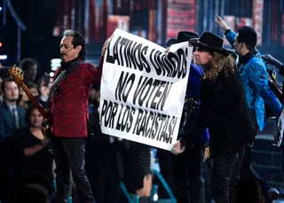 Tras la presentación del tema original de Los Tigres del Norte, los músicos de ambas bandas desplegaron un letrero que decía: 'Latinos unidos no voten por los racistas'. (AP)