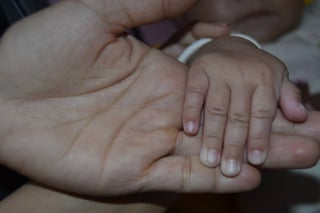 Esfuerzo. Selene toma la mano de su bebé quien hasta el momento no ha salido positivo a las pruebas prácticas de VIH, pese a que su madre es portadora. (EL SIGLO DE TORREÓN)